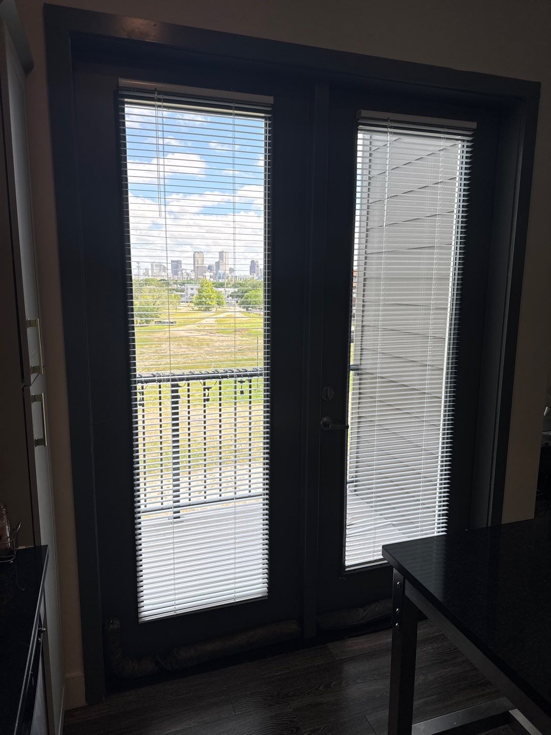 Original balcony doors at Lumina Apartments before replacement and surrounding repairs.