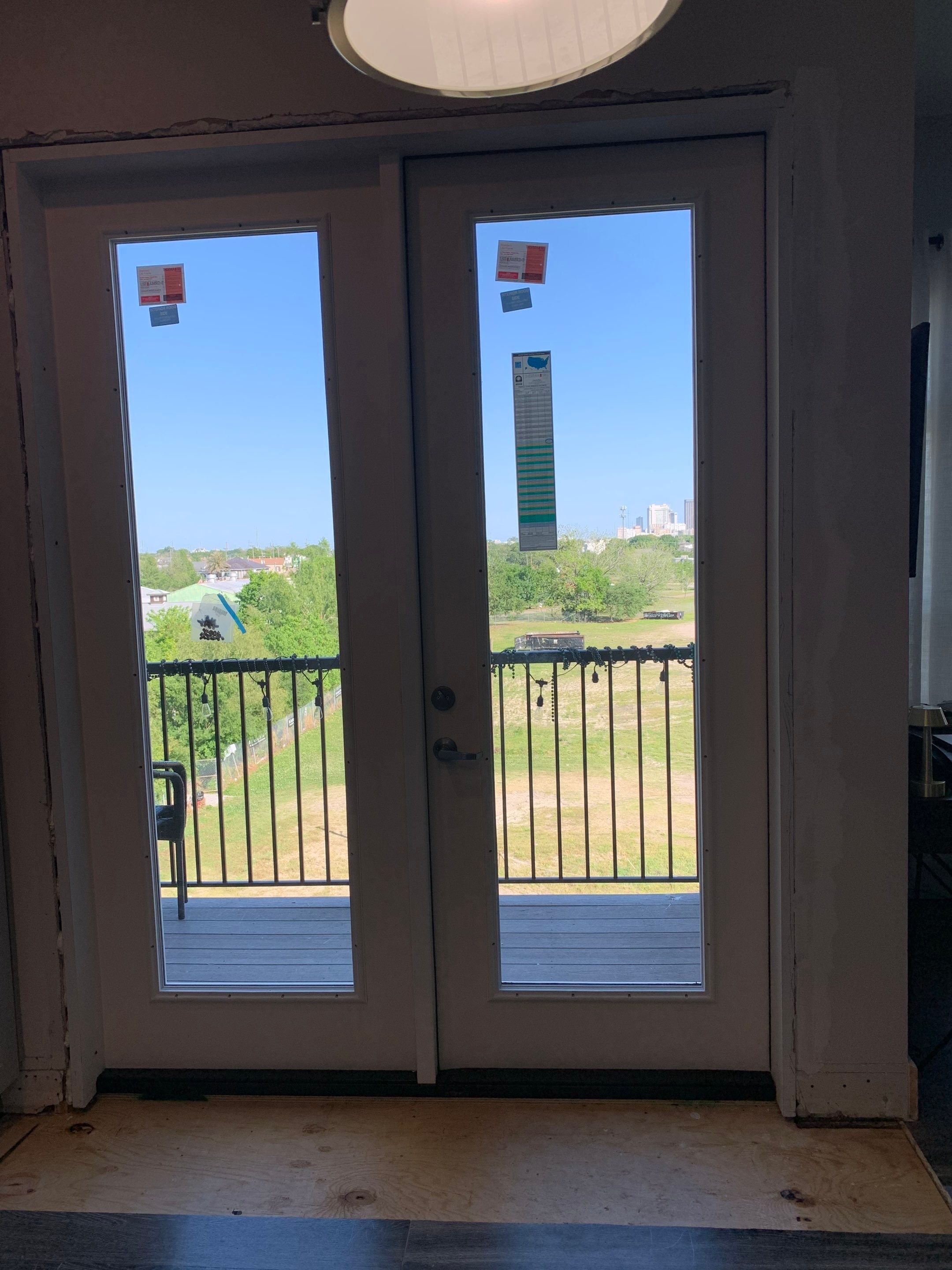 Replacement balcony doors installed with the surrounding interior trim and floor repairs still underway.