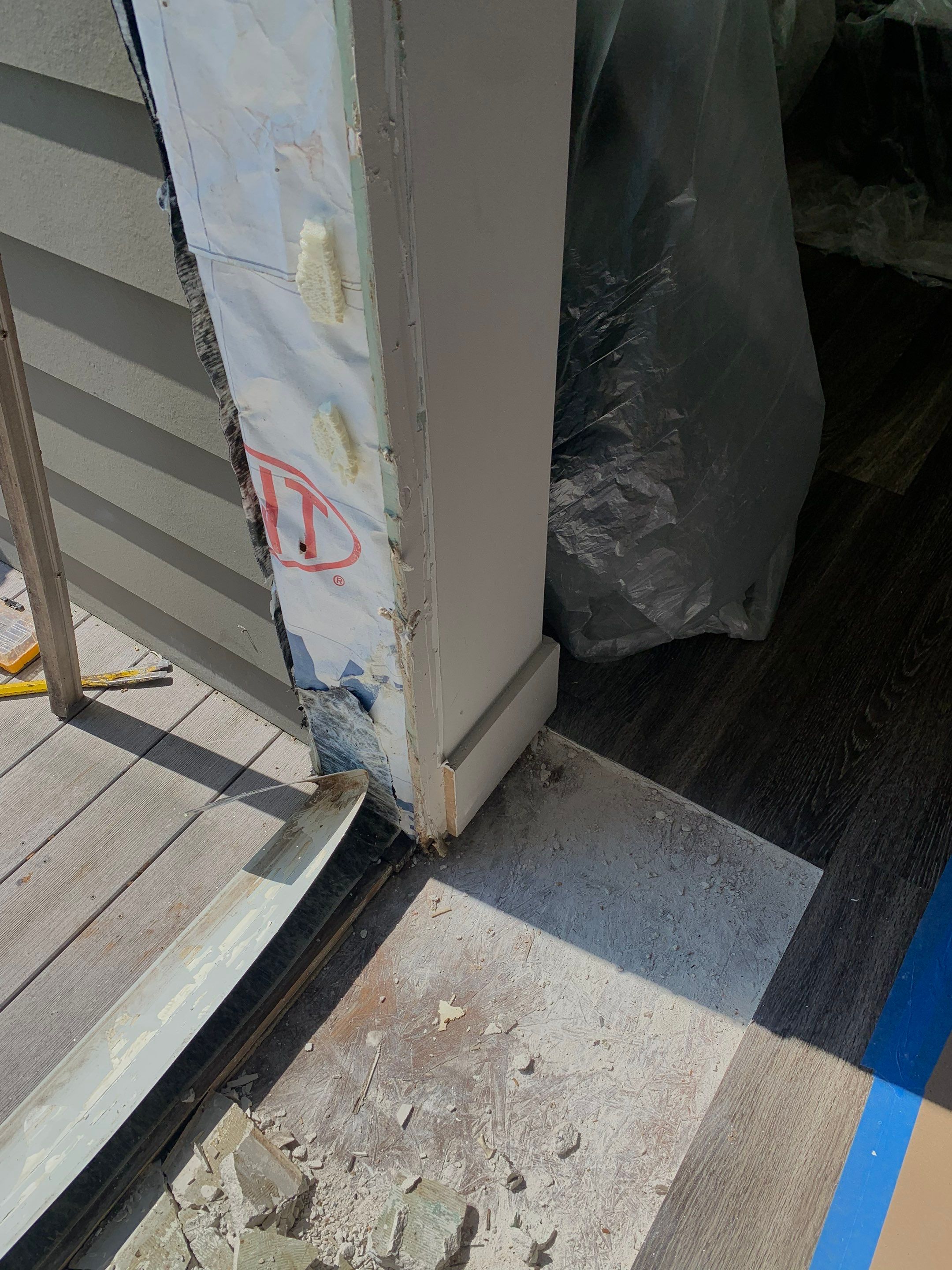 Lower door jamb with exterior weather barrier exposed for inspection and repair.