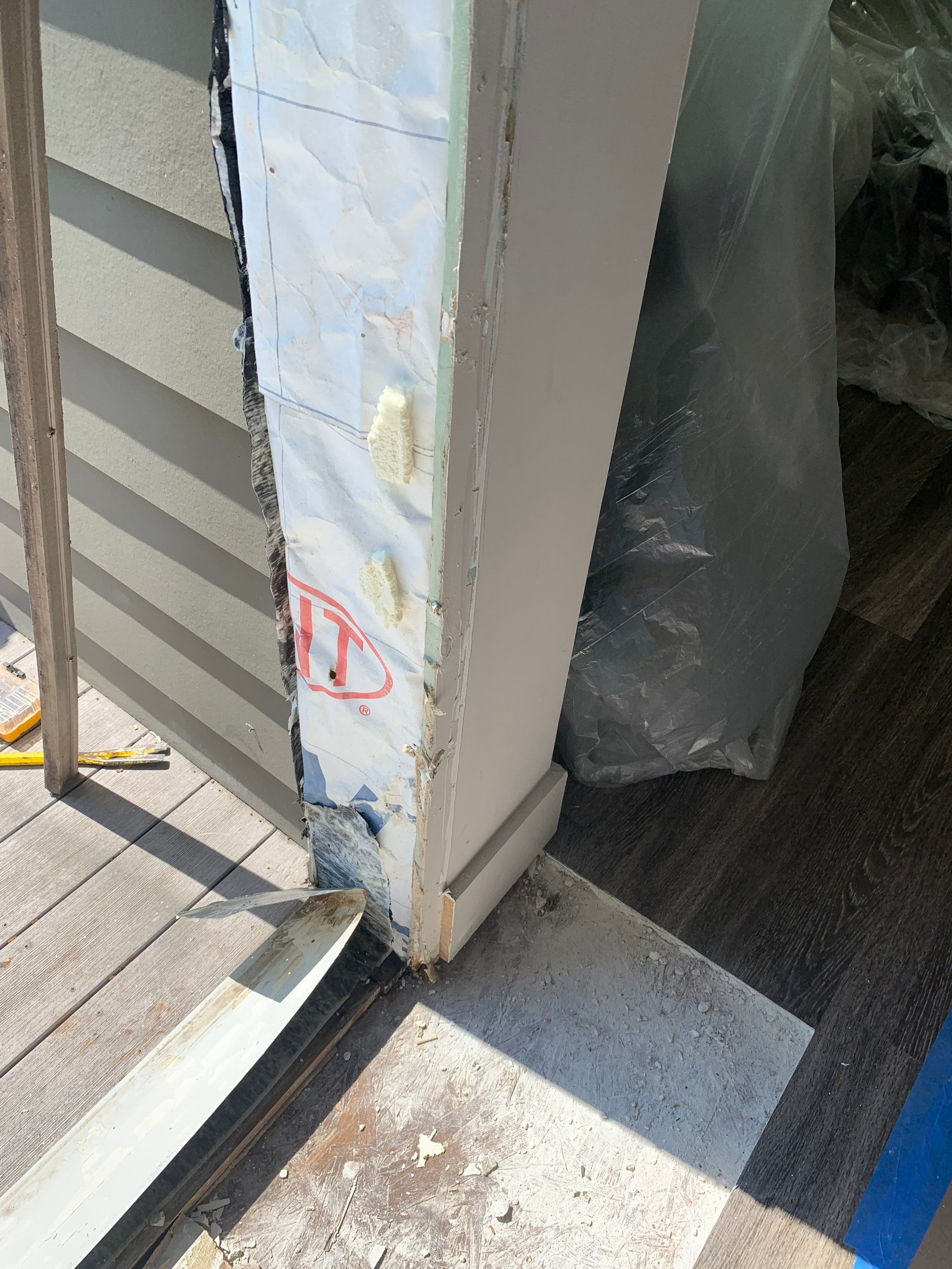 Close-up of the lower jamb and weather barrier during preparation of the replacement opening.