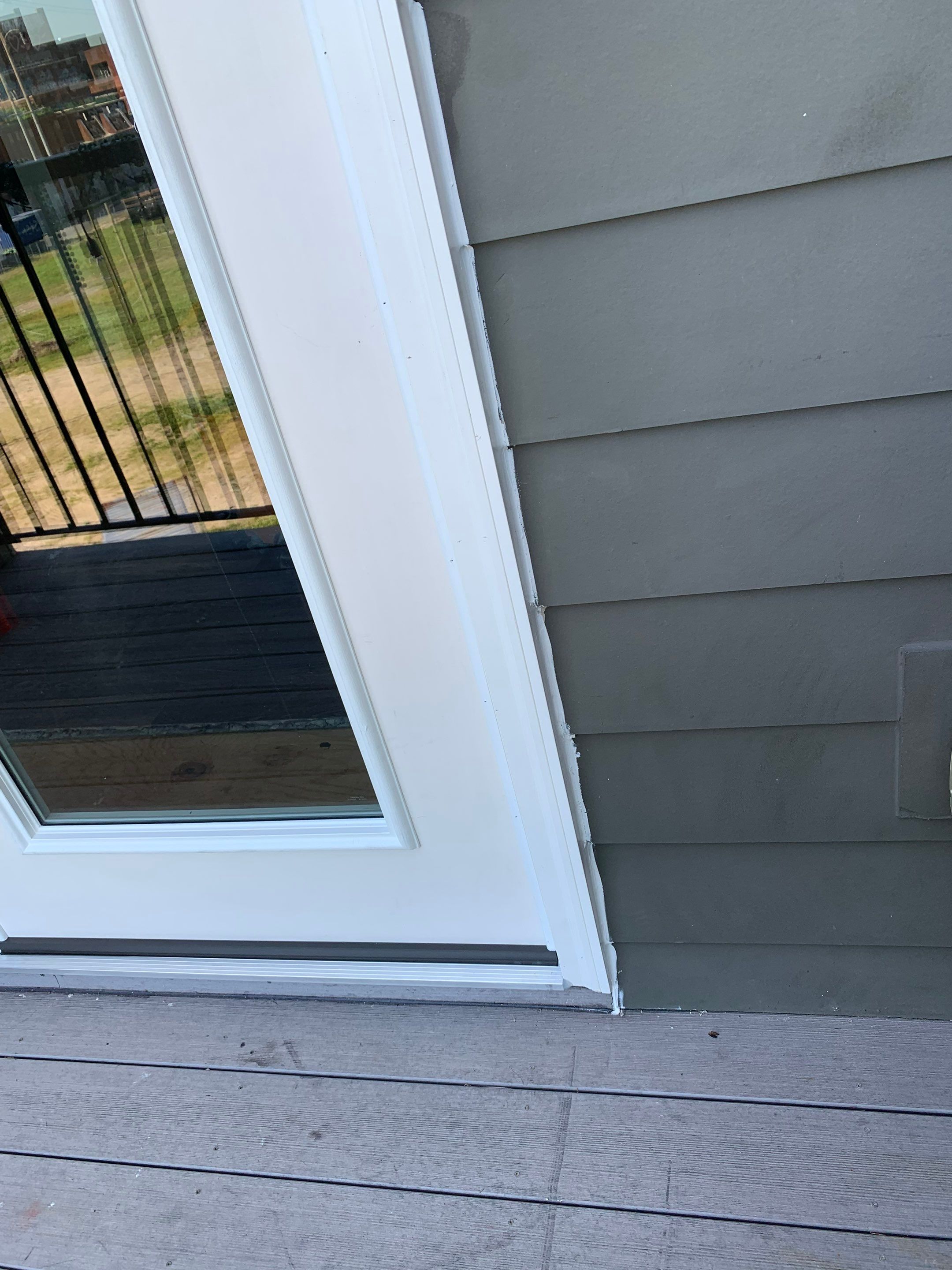 Lower corner of the replacement balcony door showing the finished exterior frame and threshold