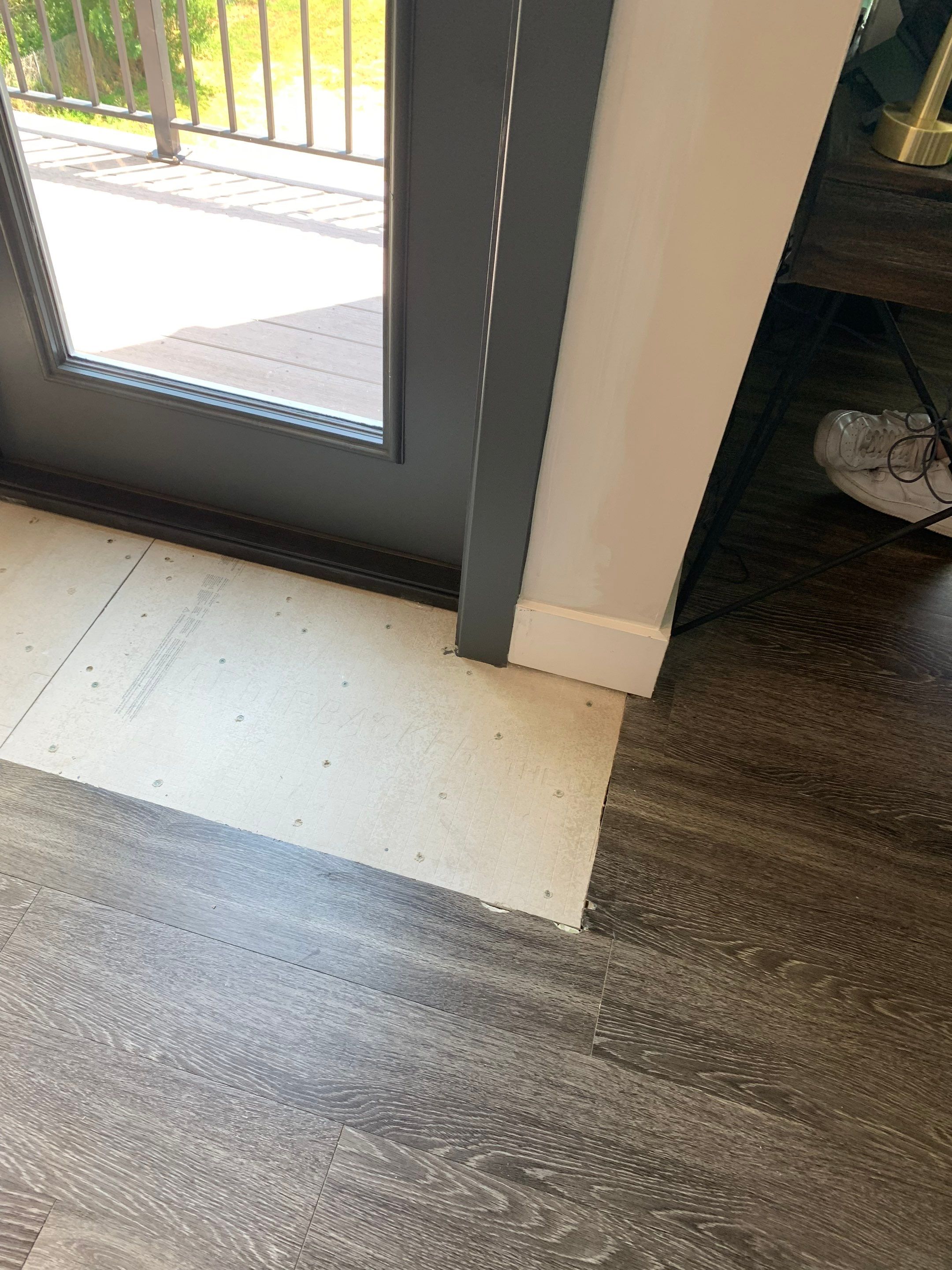 Replacement underlayment fitted around the finished door frame in preparation for matching the existing flooring.