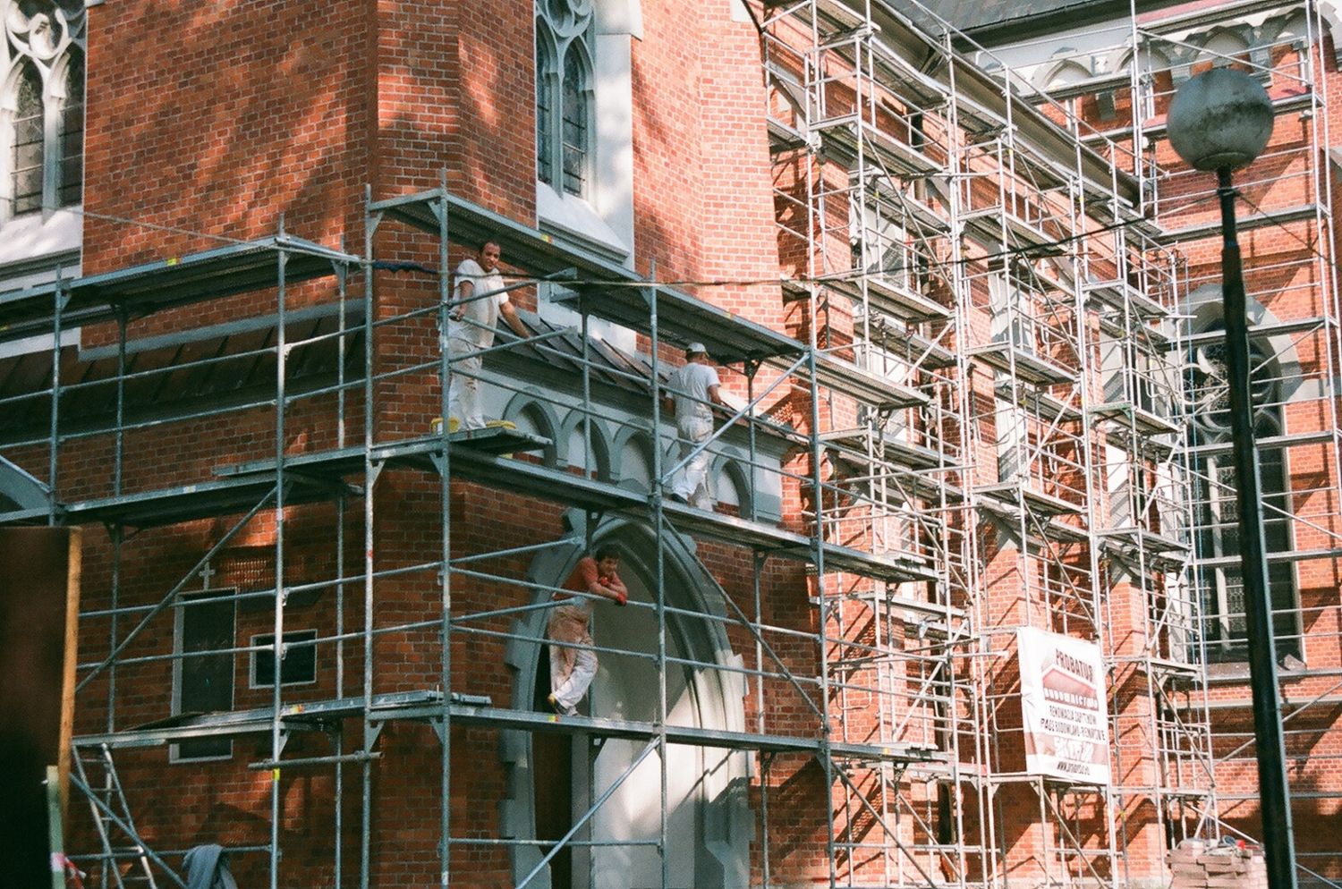 Scaffolding along the brick facade of an older building during exterior restoration