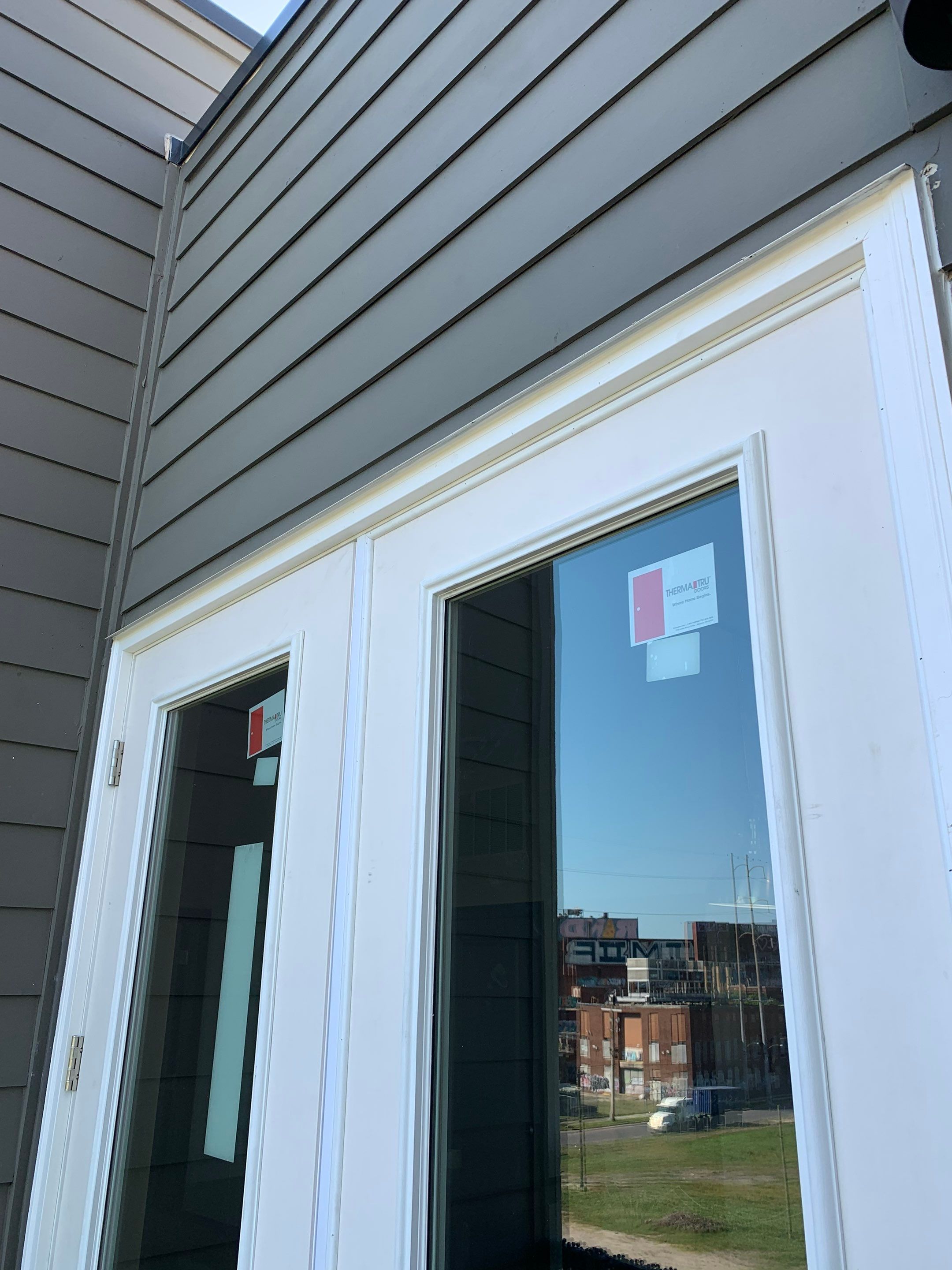Upper portion of the newly installed French doors with finished exterior trim.