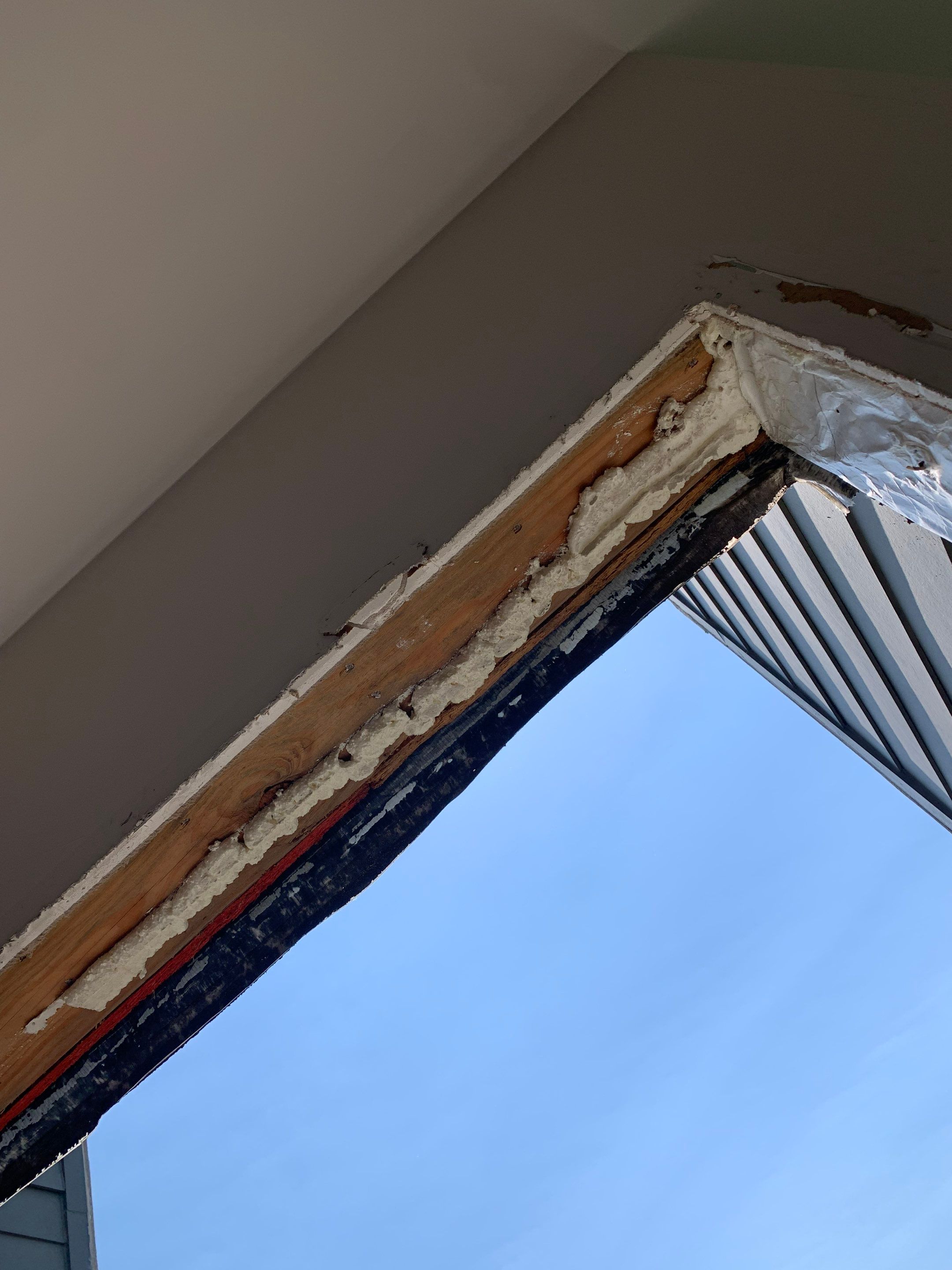 Another view of the exposed header area during balcony door demolition and preparation.