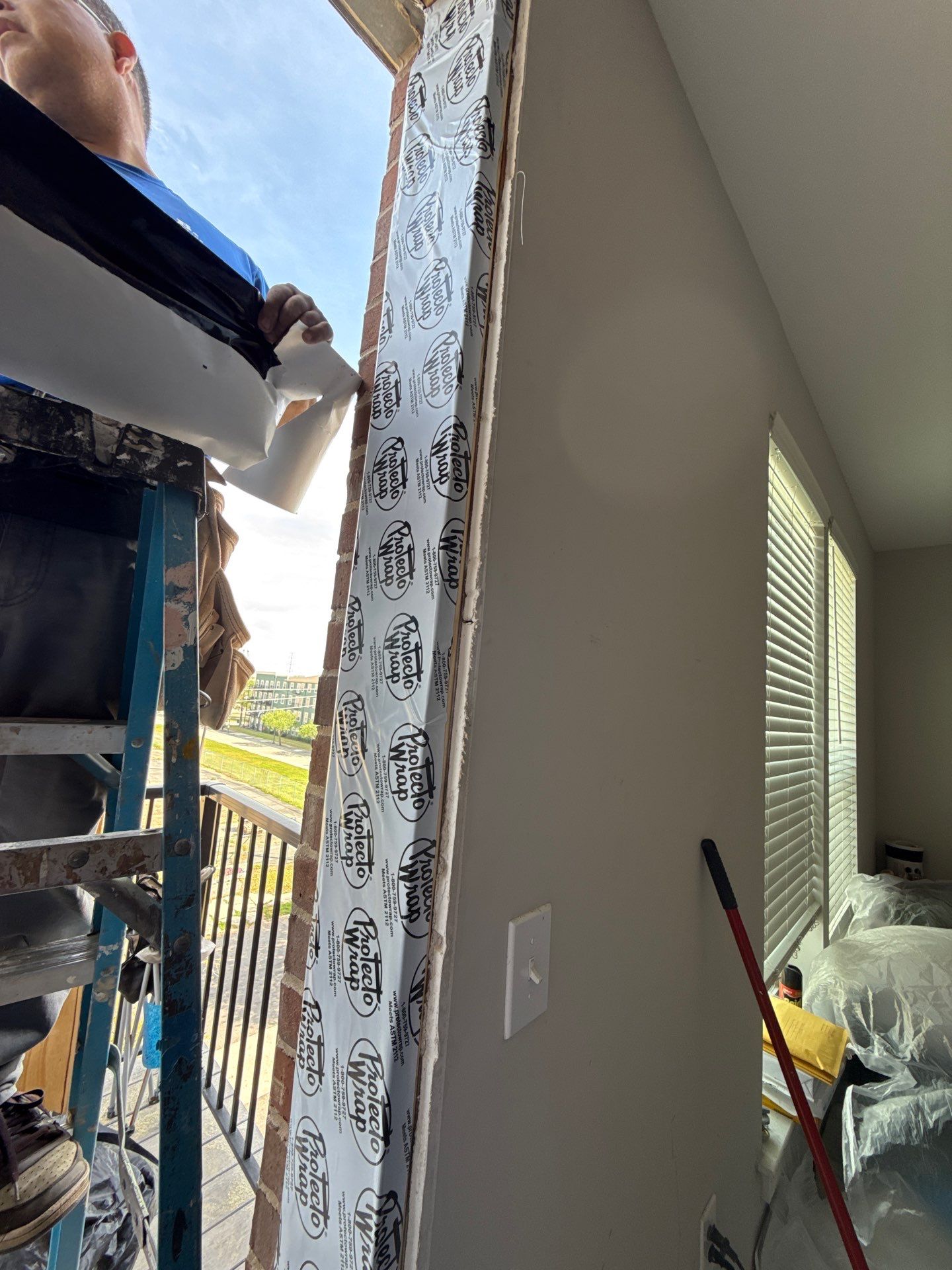Workers positioning and securing the sill area along the repaired doorway opening