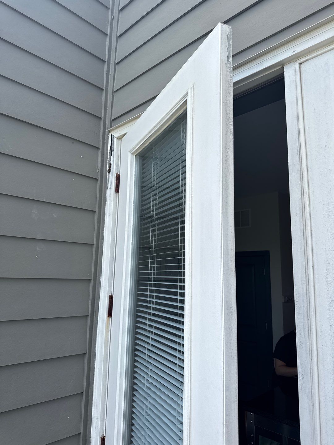 Existing balcony door and frame viewed from outside, showing the original installation.