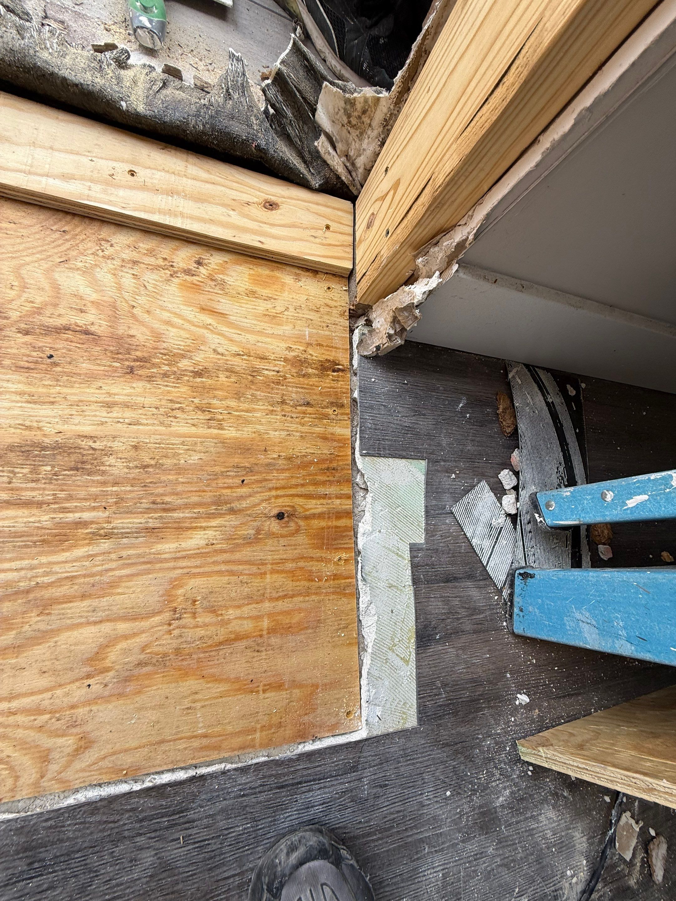 New plywood subfloor installed beside the balcony door framing, replacing damaged material