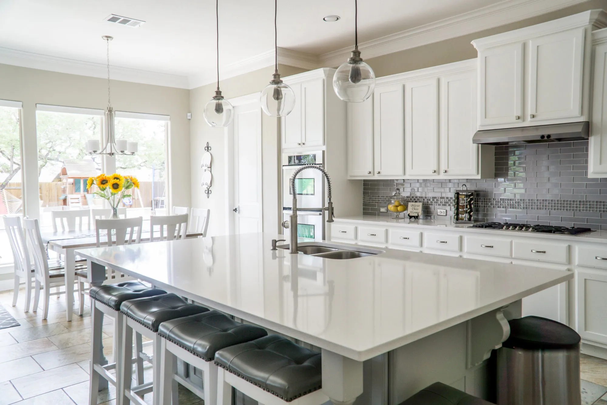 Bright white kitchen with a large island and pendant lights