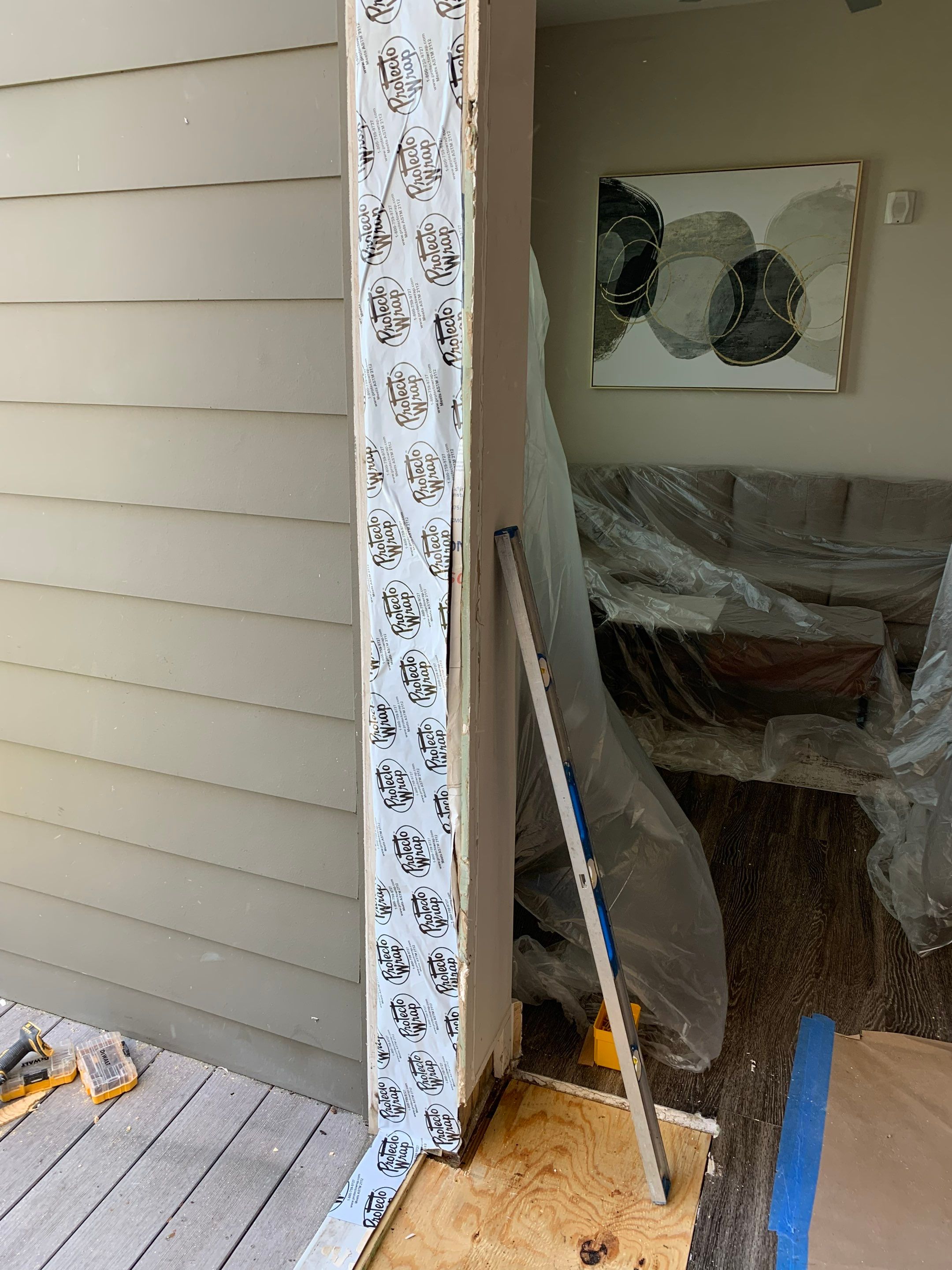 Exterior side of the doorway prepared with weather barrier and replacement subfloor.