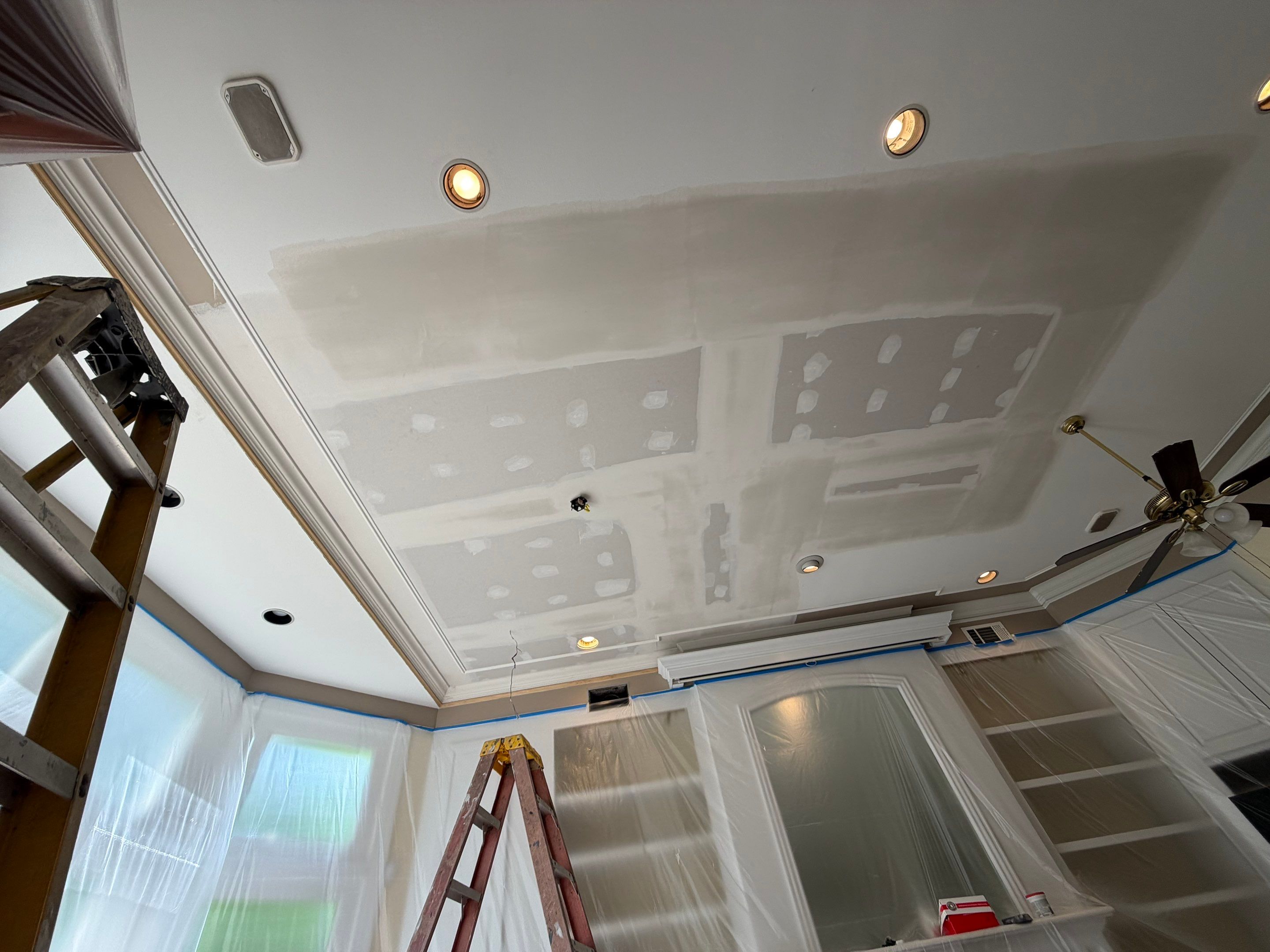 Replacement ceiling drywall installed, with seams and fasteners treated in preparation for final finishing.