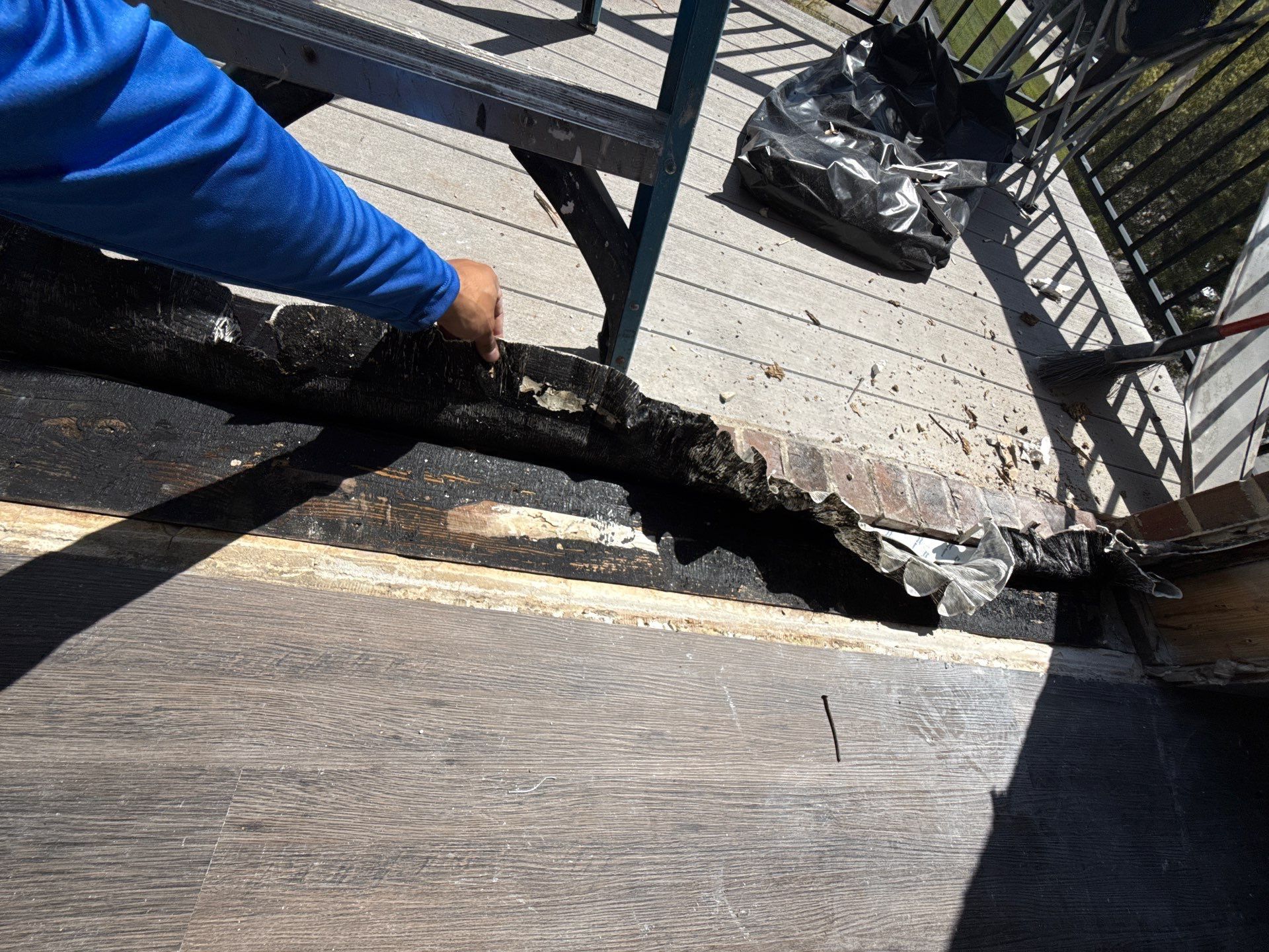 Contractor lifting deteriorated black threshold membrane