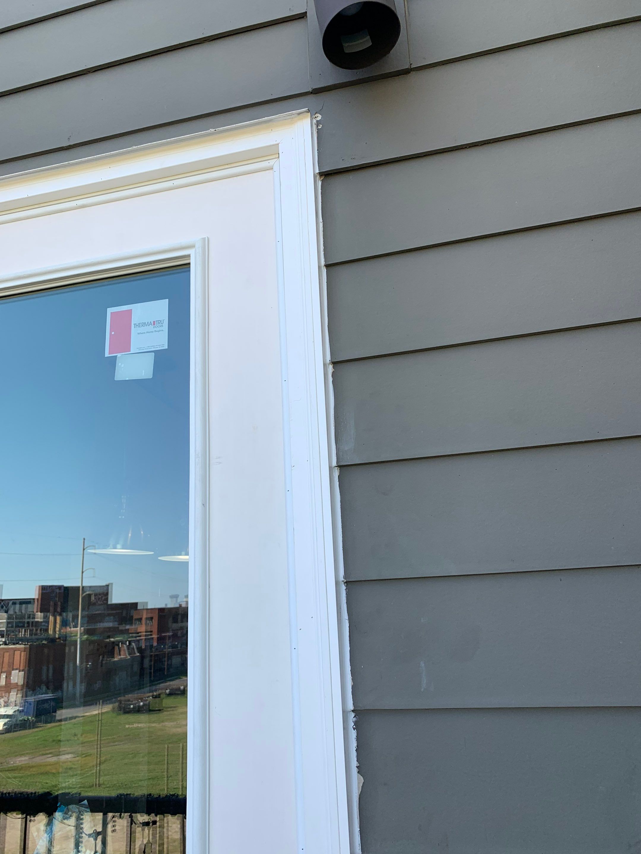 Exterior view of the replacement door frame and its connection to the surrounding siding.