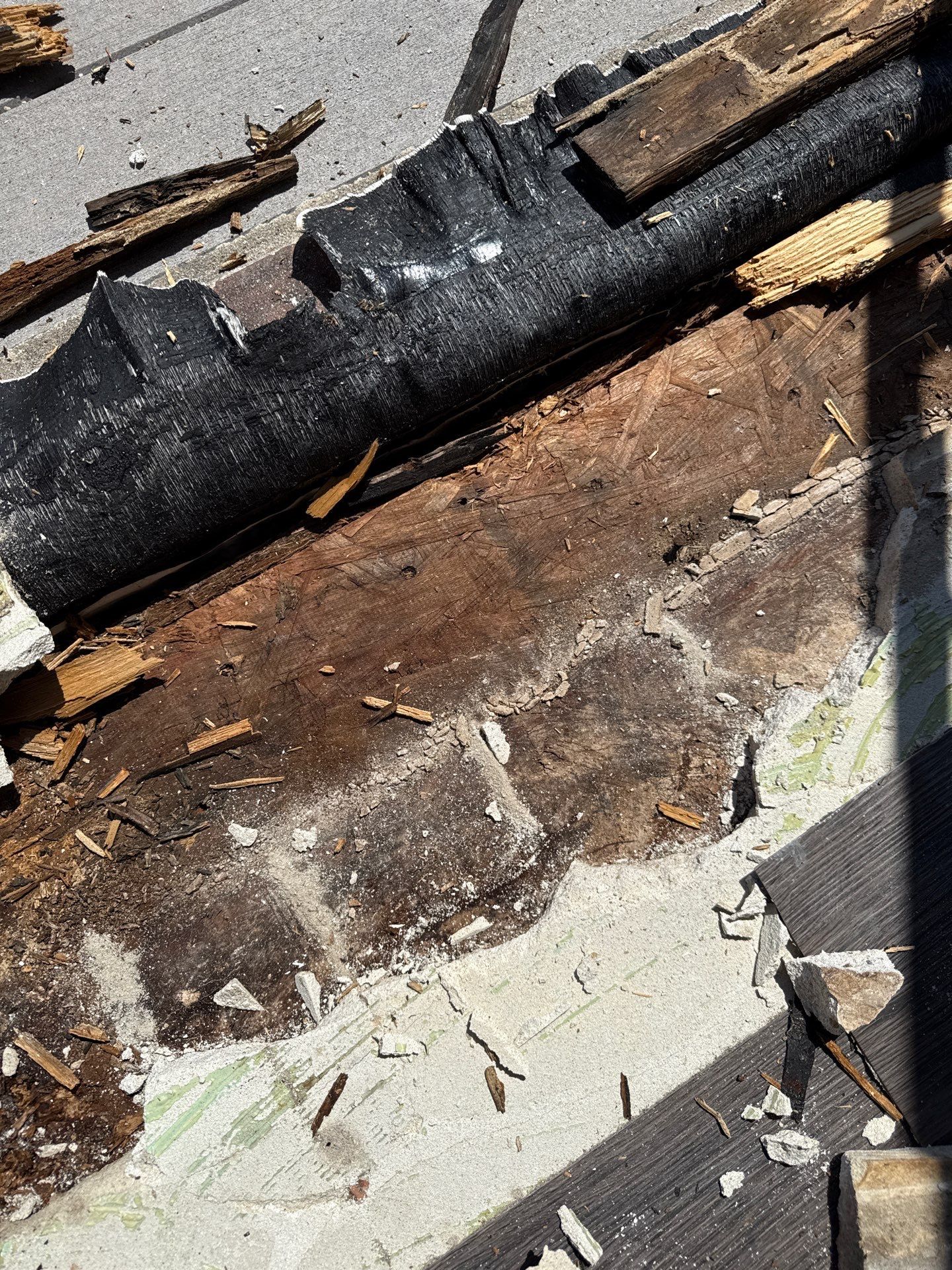 Detailed view of deteriorated wood along the balcony door opening, showing the extent of damage beneath the original threshold