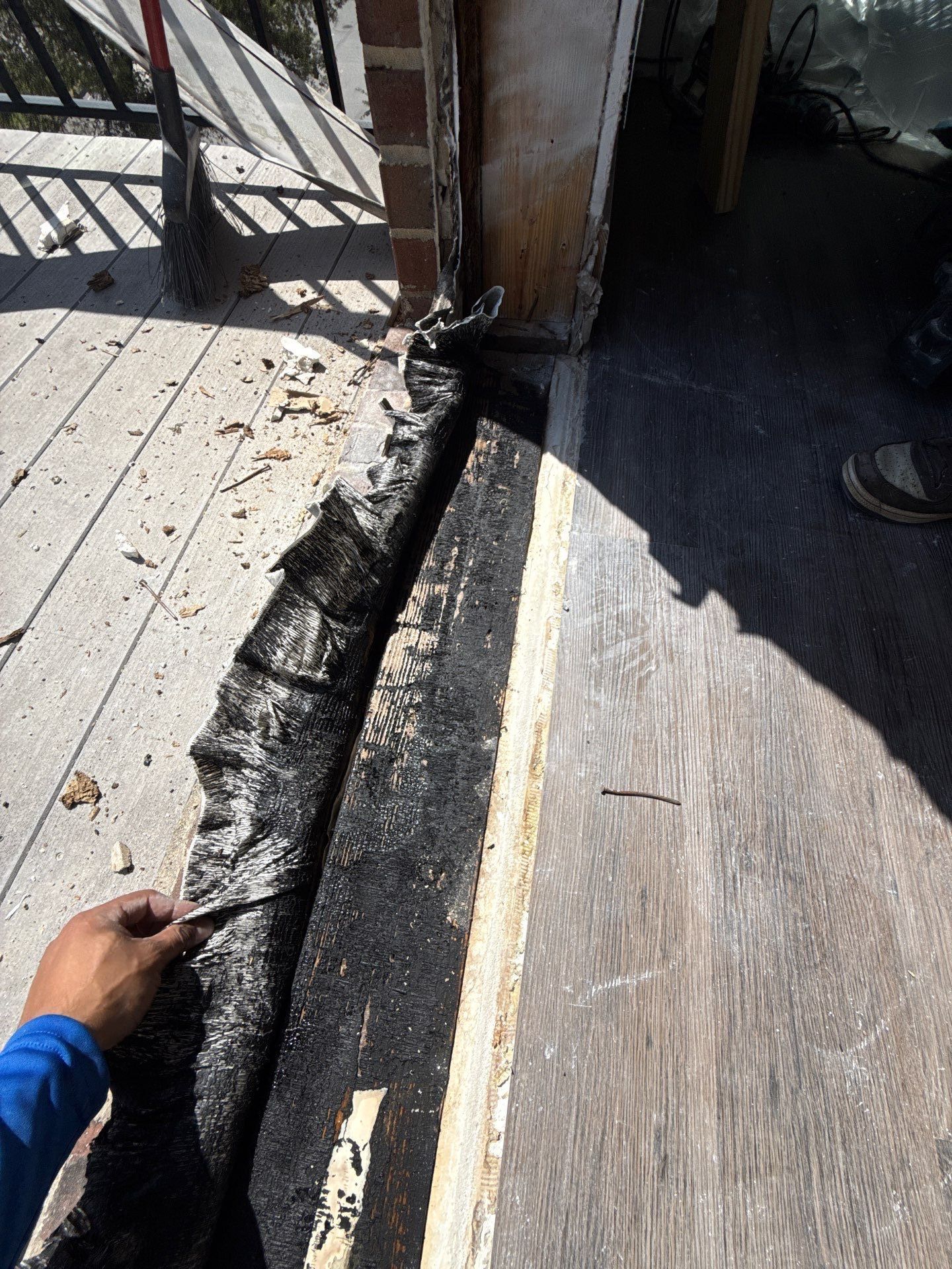 Damaged threshold membrane peeled up to expose substrate