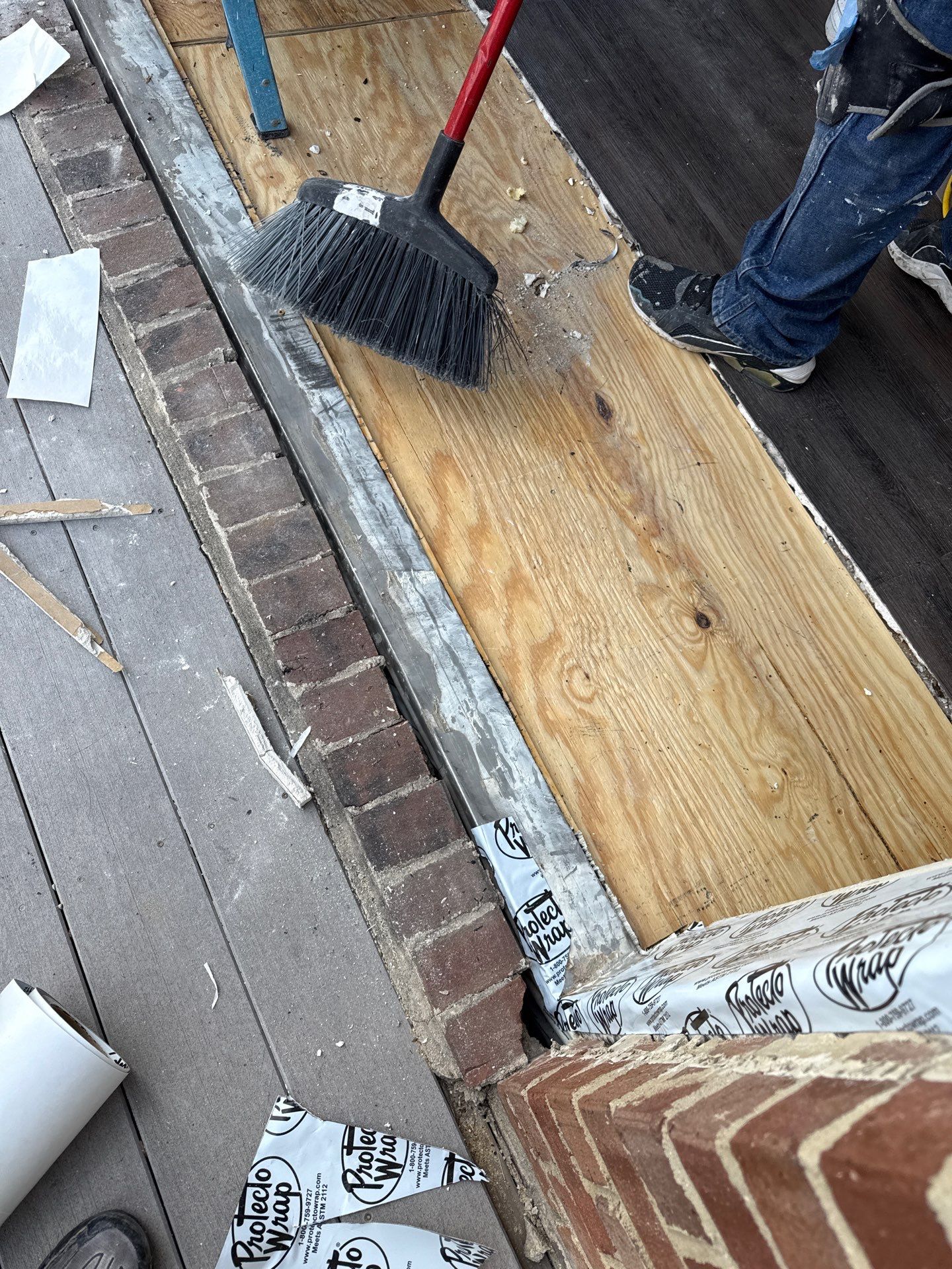 Close-up of the new door frame at the brick opening, showing the flashing and installation details
