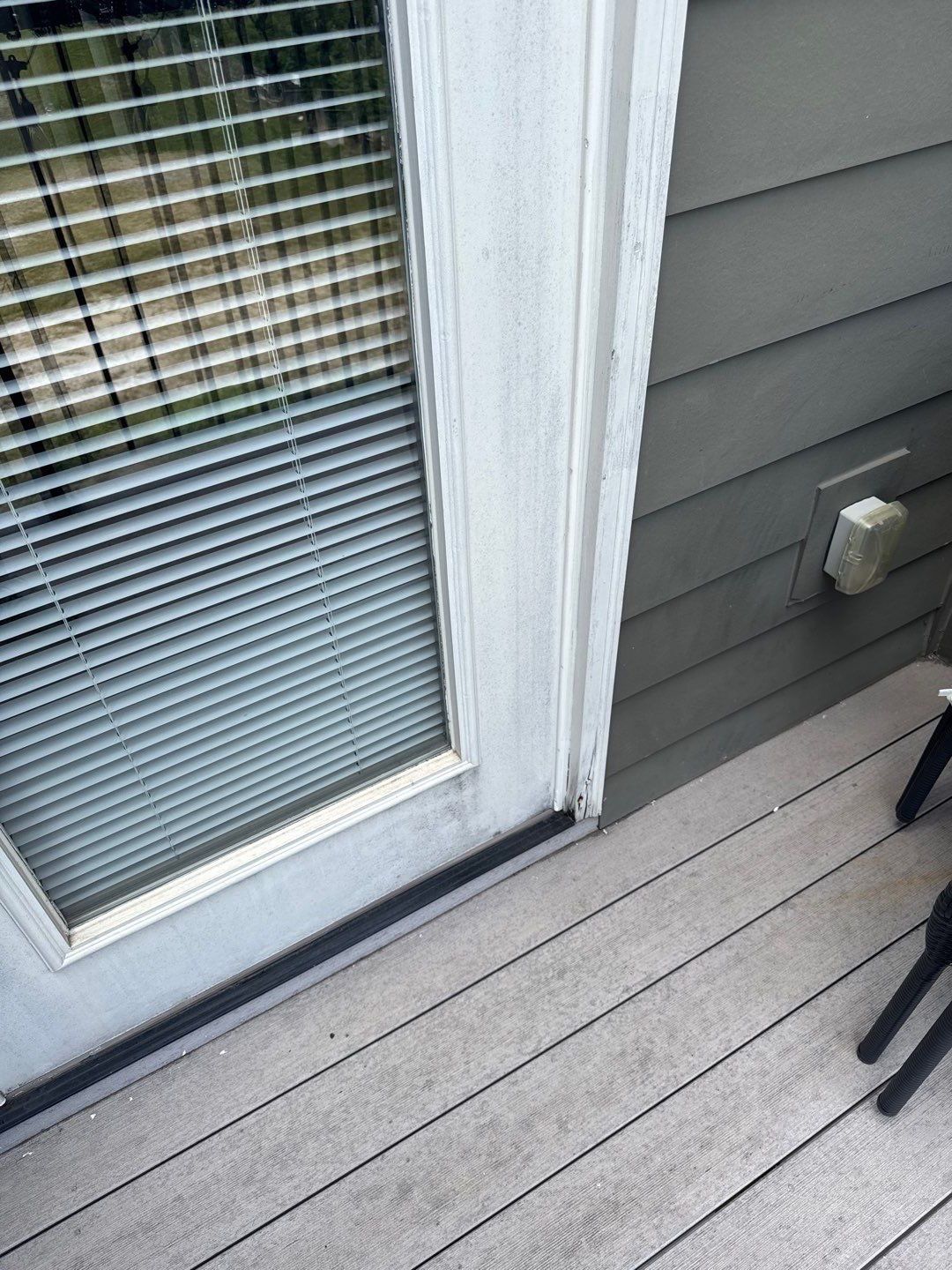 Close-up of the existing balcony door threshold and exterior trim before removal.