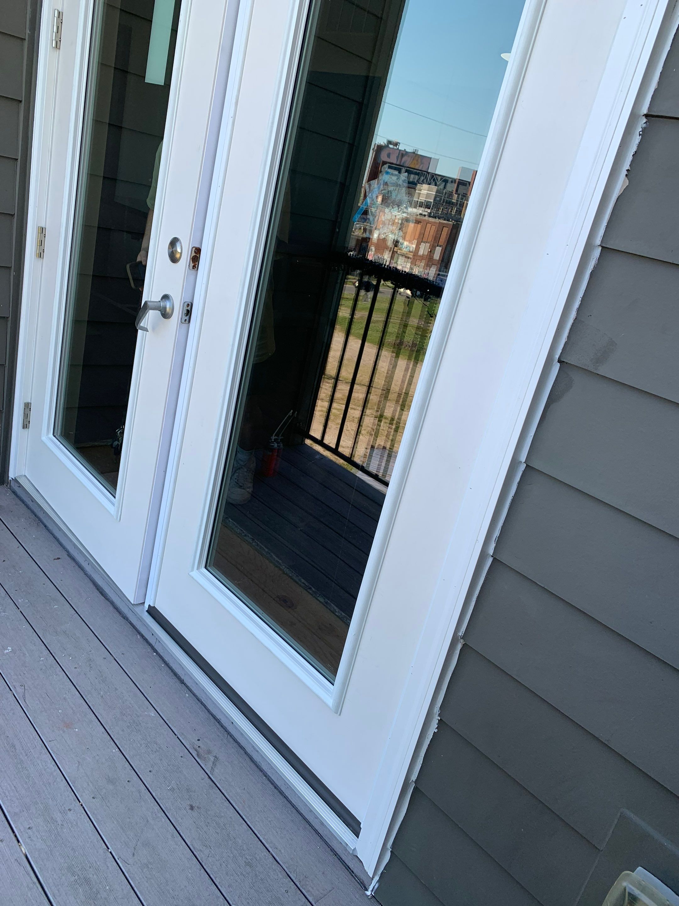 Balcony-side view of the replacement French doors with full-height glass panels.