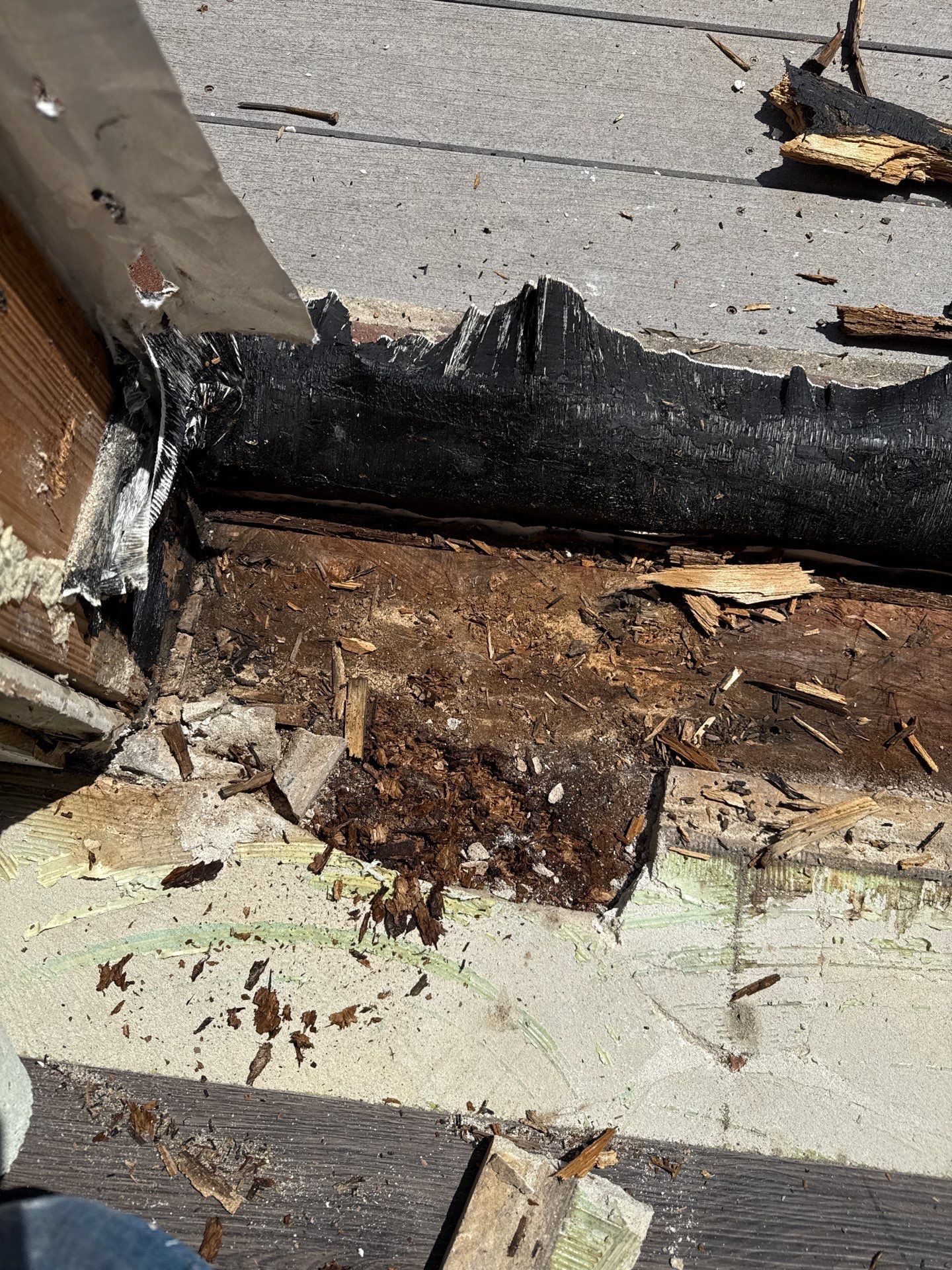 Additional view of the moisture-damaged subfloor and deteriorated wood discovered during threshold removal