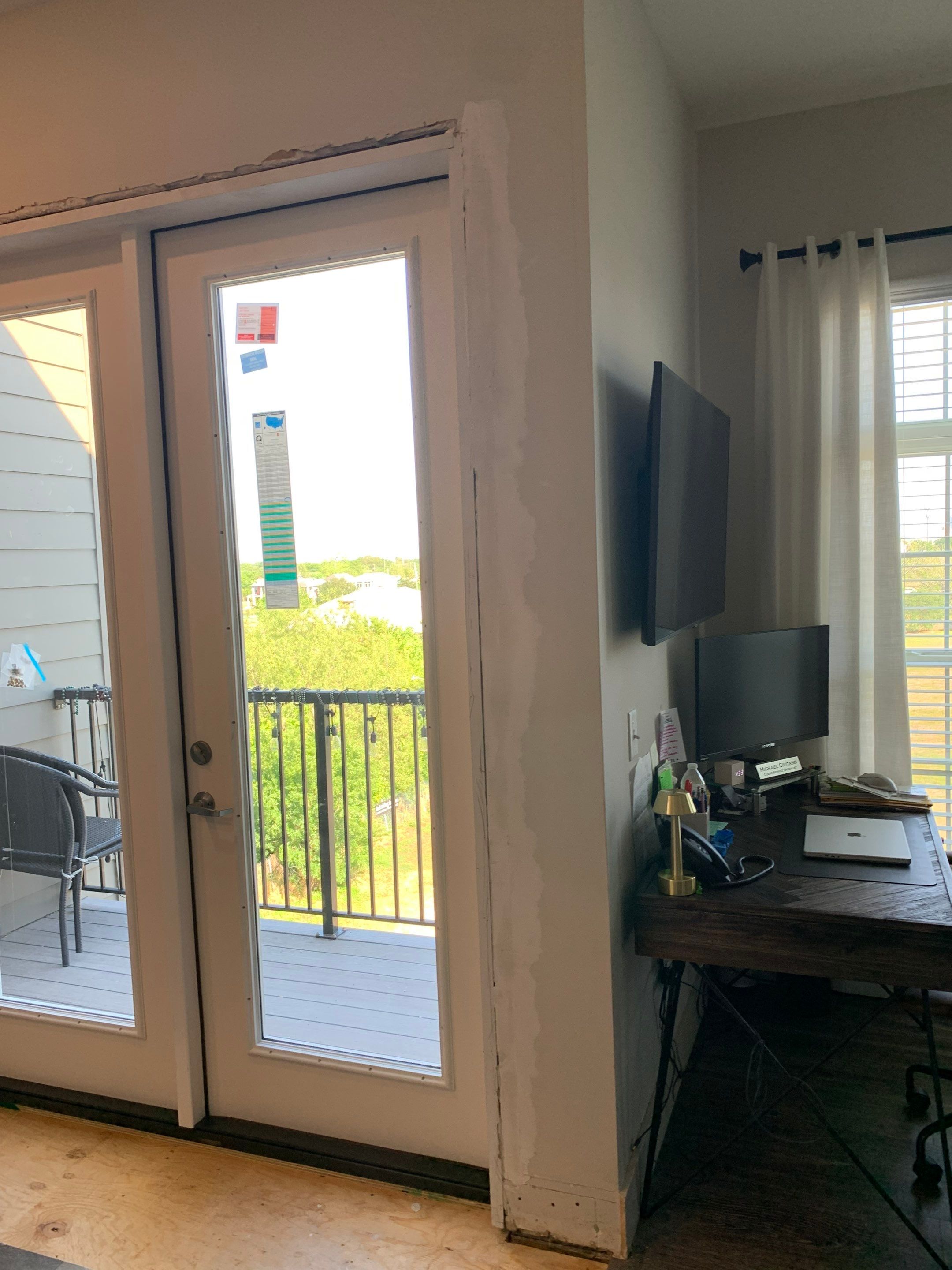 Replacement French doors installed while the surrounding interior wall and trim repairs remain in progress.